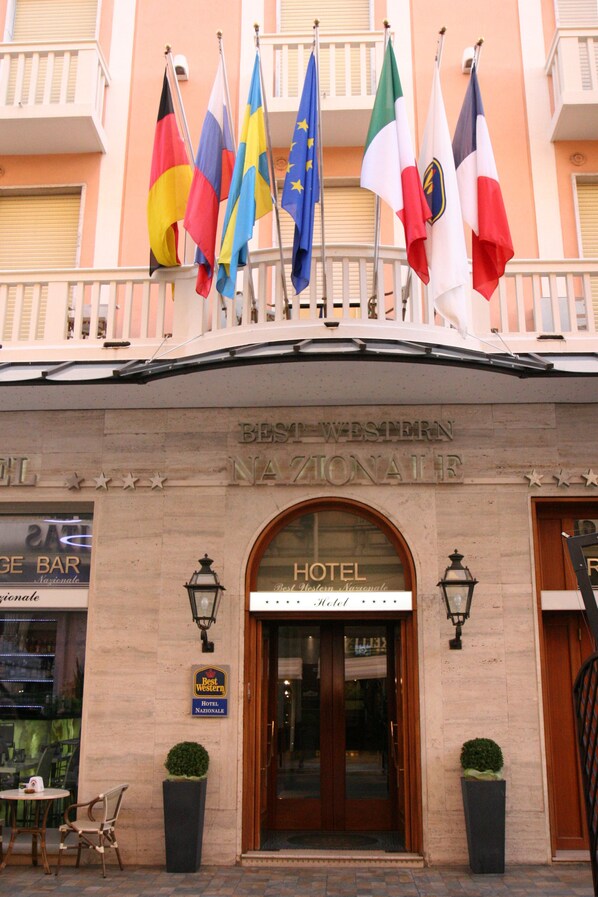 A hotel facade with multiple flags, a sign reading "Best Western NAZIONALE," and a "HOTEL" sign above the entrance. - Best Western Hotel Nazionale (Sanremo)