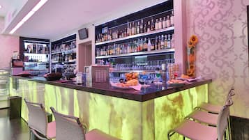 Eine Bar mit einer Theke, mehreren Flaschenregalen und Barhocker.