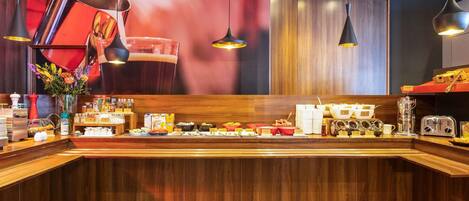 A modern hotel reception area with a wooden counter, various amenities, and a large poster on the wall.