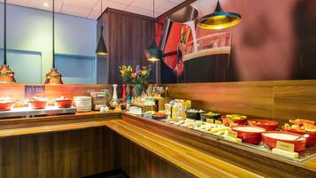Een ontbijtbuffet met diverse etenswaren en een bordje met de tekst 'TRY OUR BOILED ALA'.