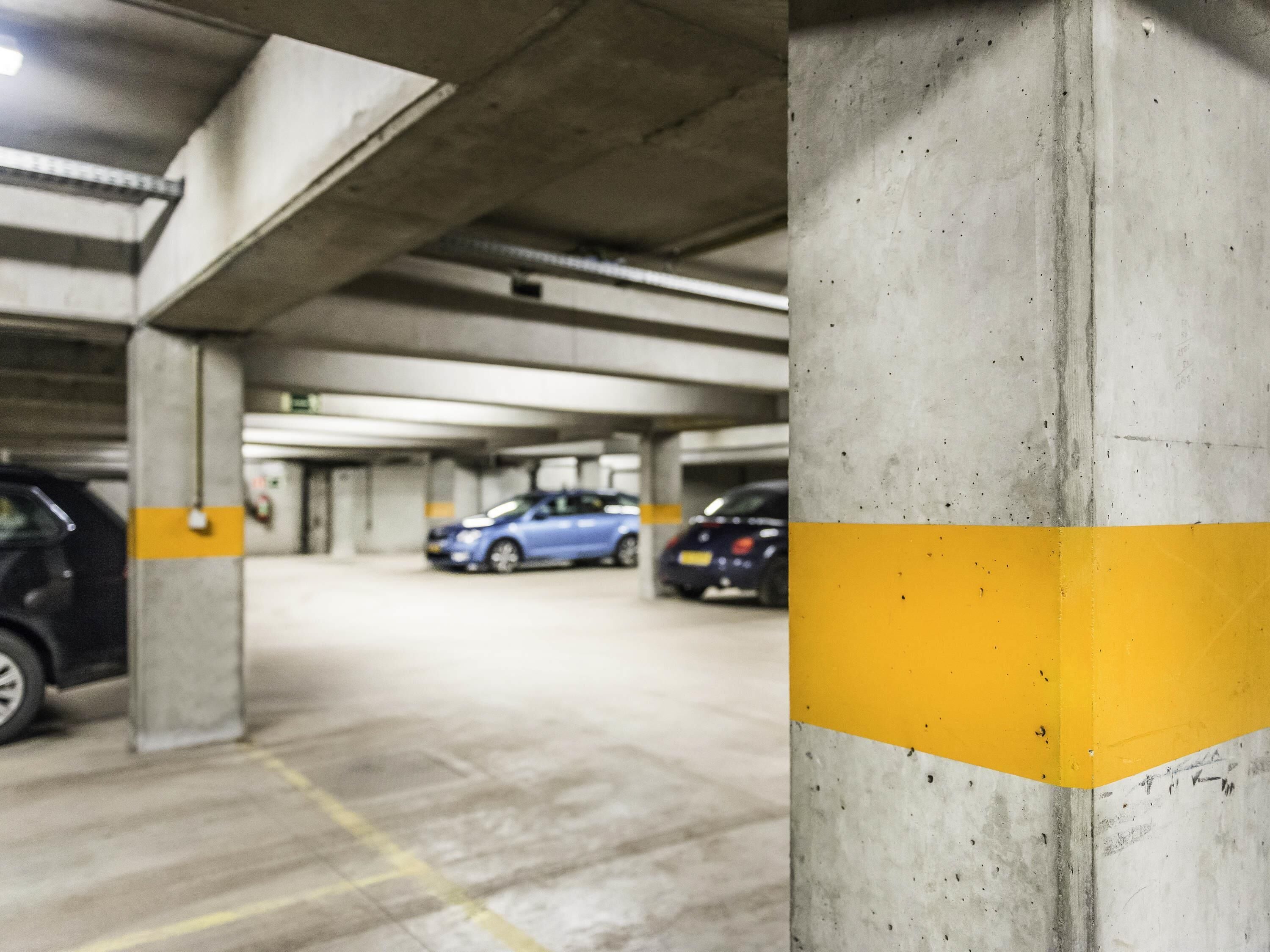 A multi-level parking garage with concrete pillars and yellow safety lines.