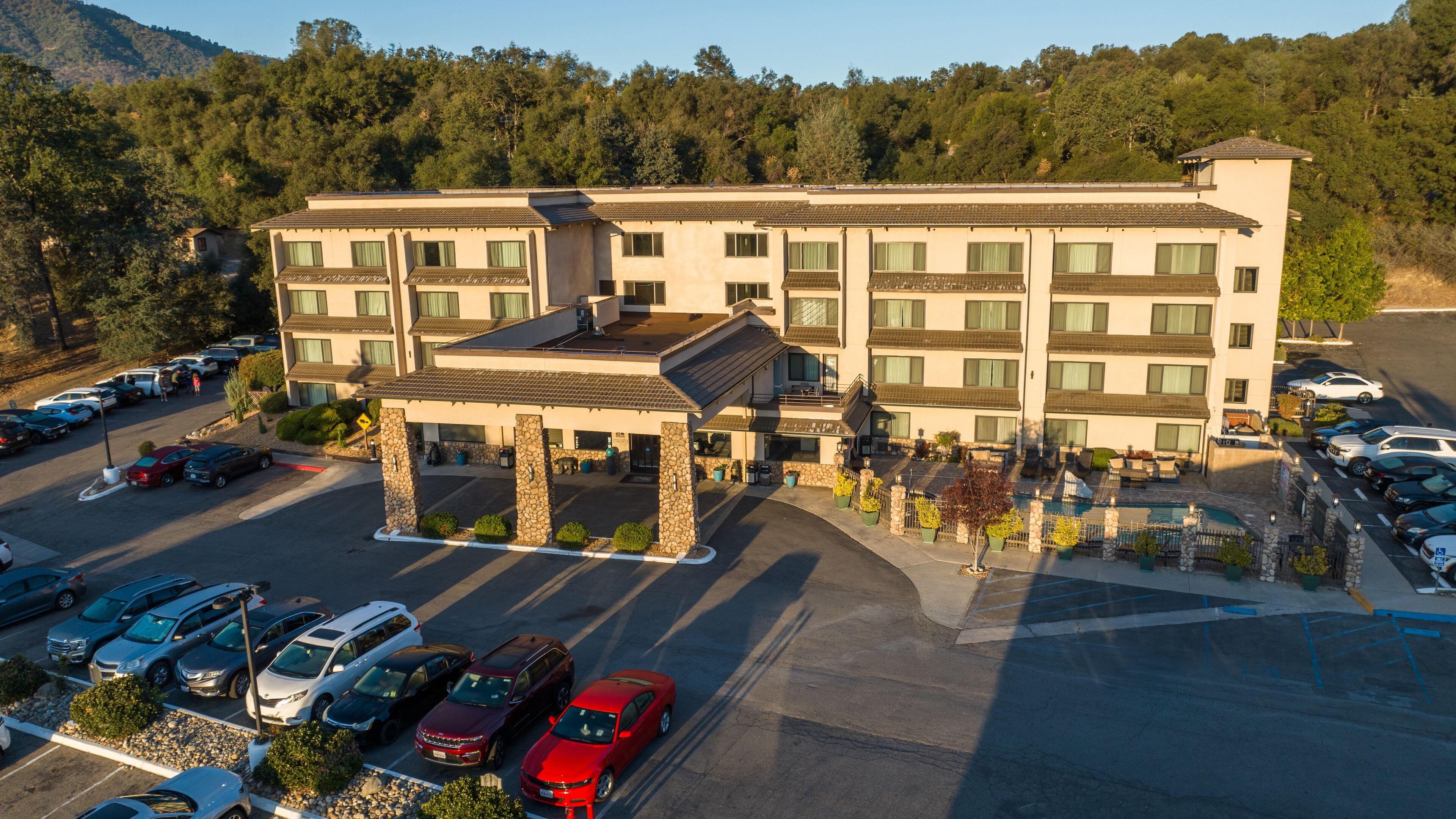 A multi-story hotel with a covered entrance and a parking lot.