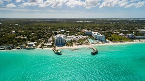 Ein Luftbild eines Küstenresorts mit Strand, einer Marina und mehreren Gebäuden.