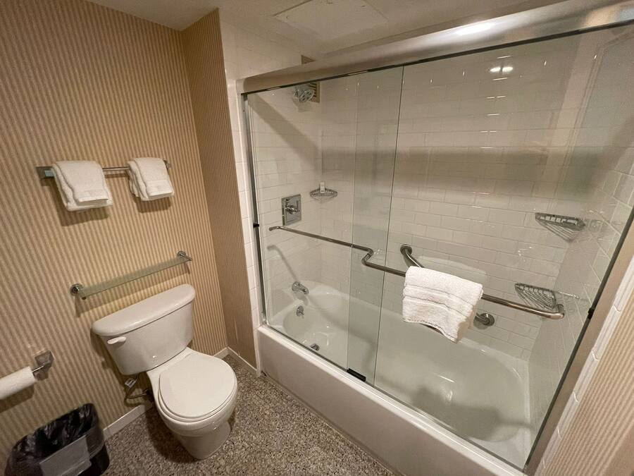 A bathroom with a glass-enclosed shower, a toilet, and a bathtub.