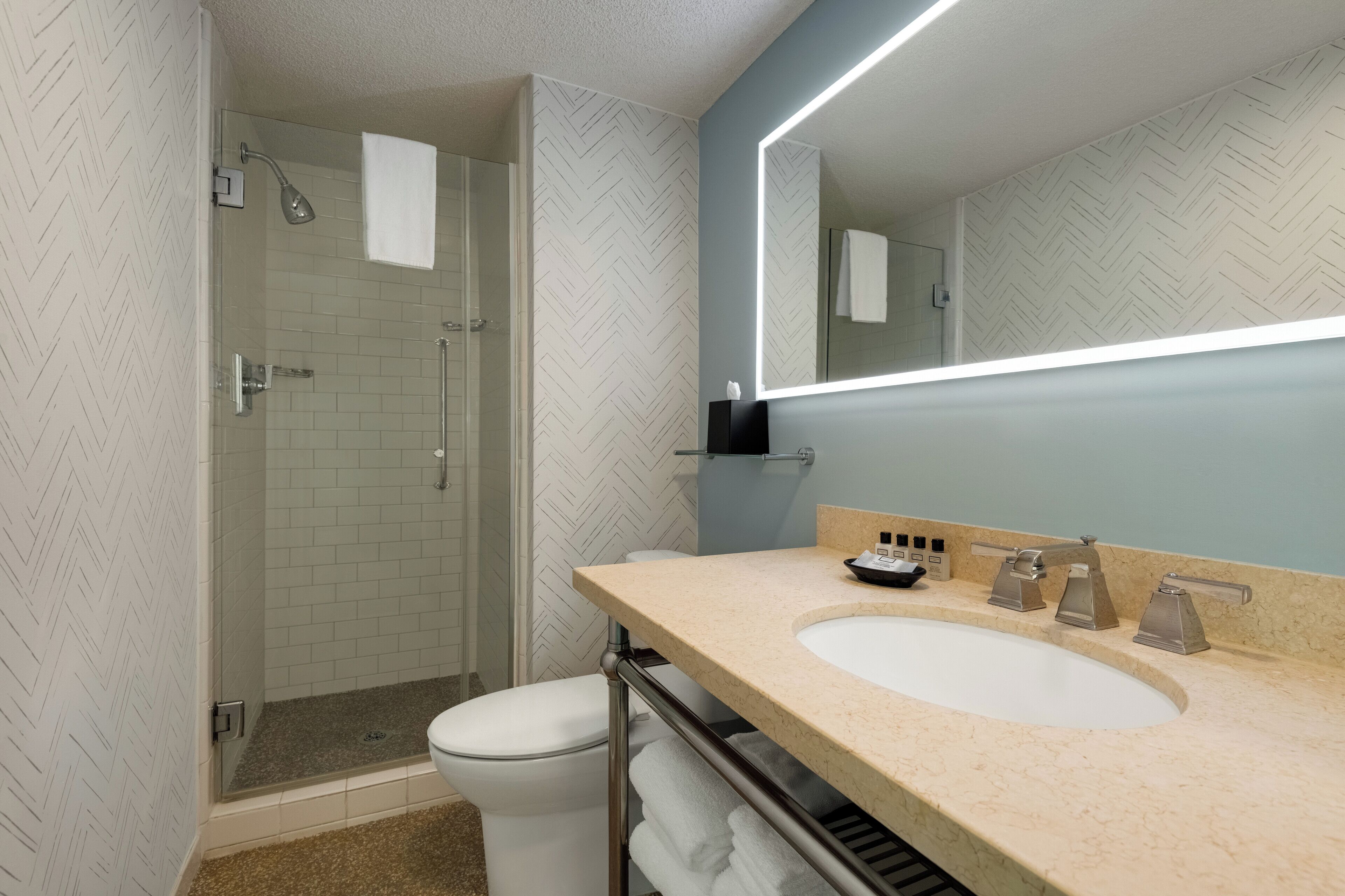 Un baño moderno con ducha, inodoro y lavamanos.