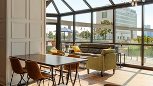 Un interno moderno con zona pranzo, posti a sedere e ampie finestre con vista sulla città.