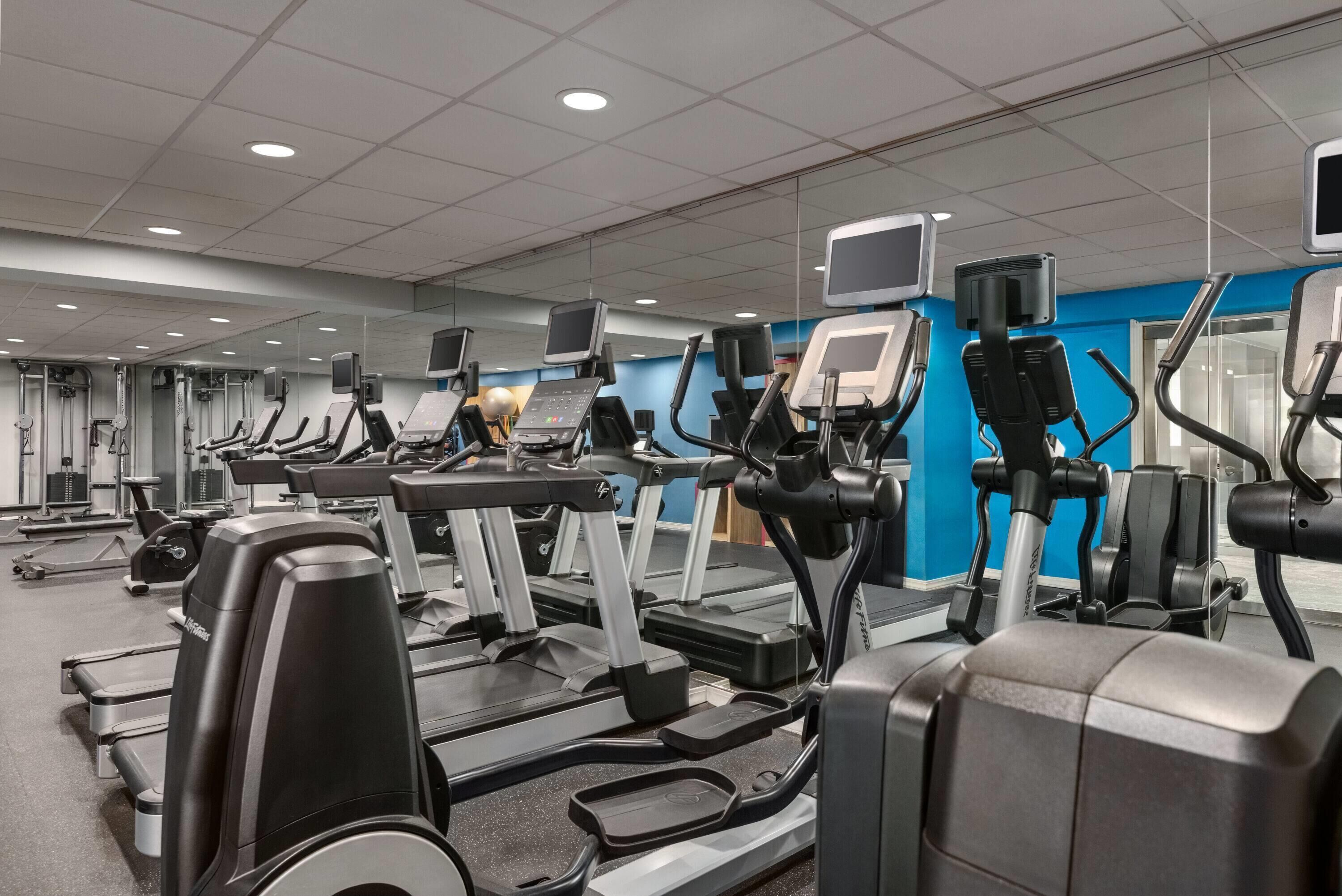 A gym with multiple treadmills, stationary bikes, and weight machines.