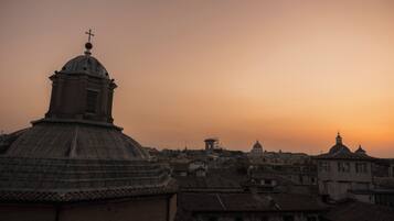 Un edificio storico con una cupola e una croce, circondato da architettura tradizionale.