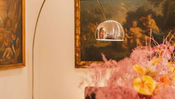 Une pièce avec un échiquier, une lampe et un tableau accroché au mur.