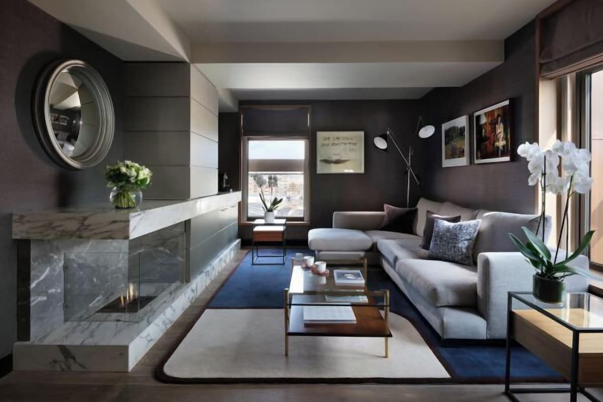 A modern living room with a sofa, coffee table, and a fireplace.
