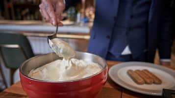 A person scooping a creamy substance from a red bowl.