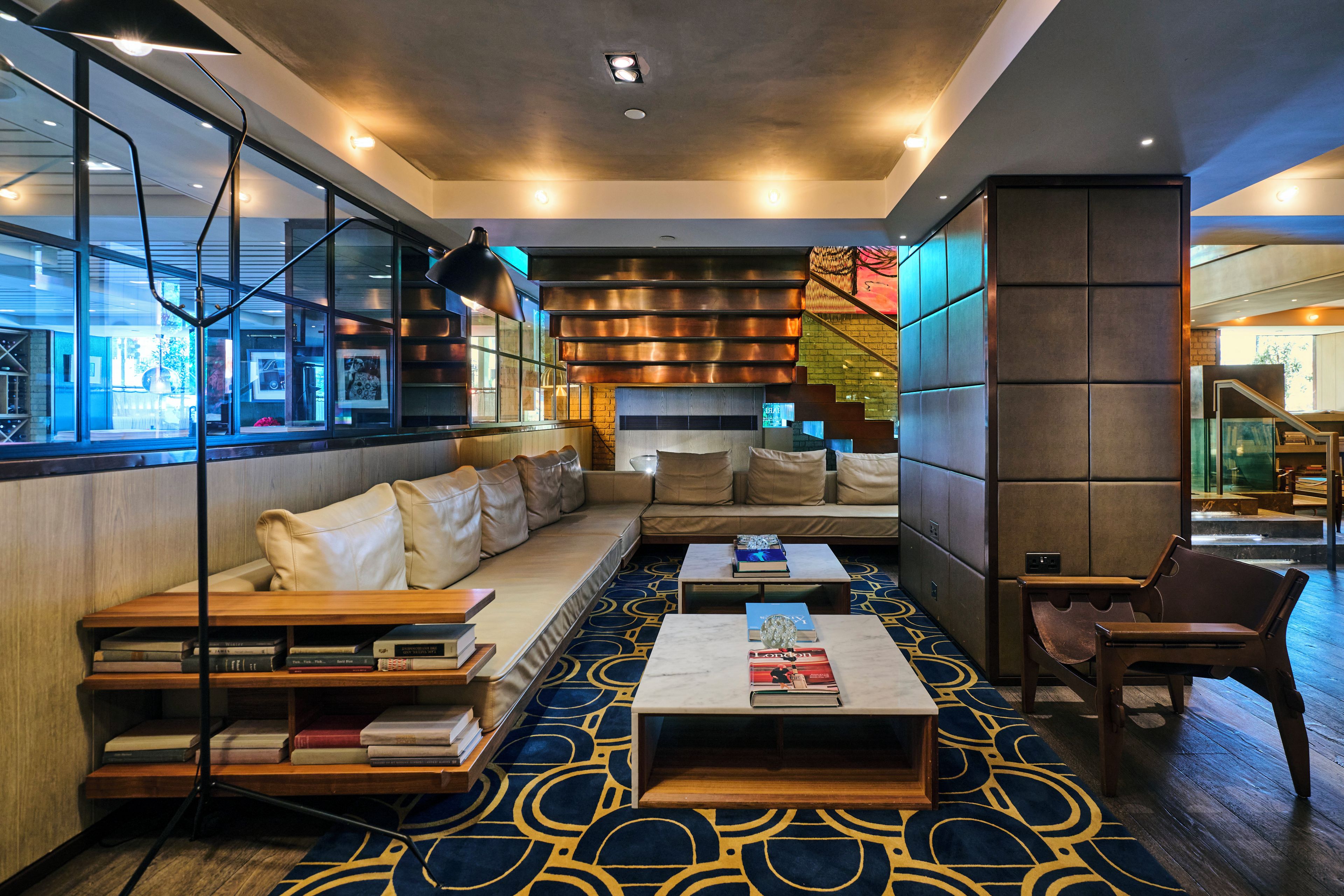 Ein stilvoller Lounge-Bereich mit einer Couch, einem Couchtisch und Bücherregalen.