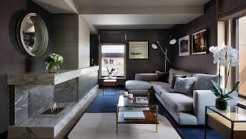 A modern living room with a fireplace, a sofa, a coffee table, and a large mirror.