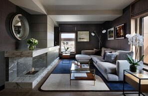 Una sala de estar moderna con chimenea, un sofá, una mesa de centro y un espejo grande.
