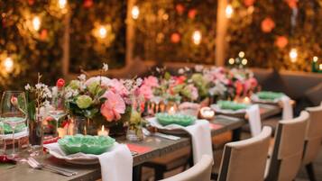 A dining table set with plates, cutlery, and floral centerpieces.