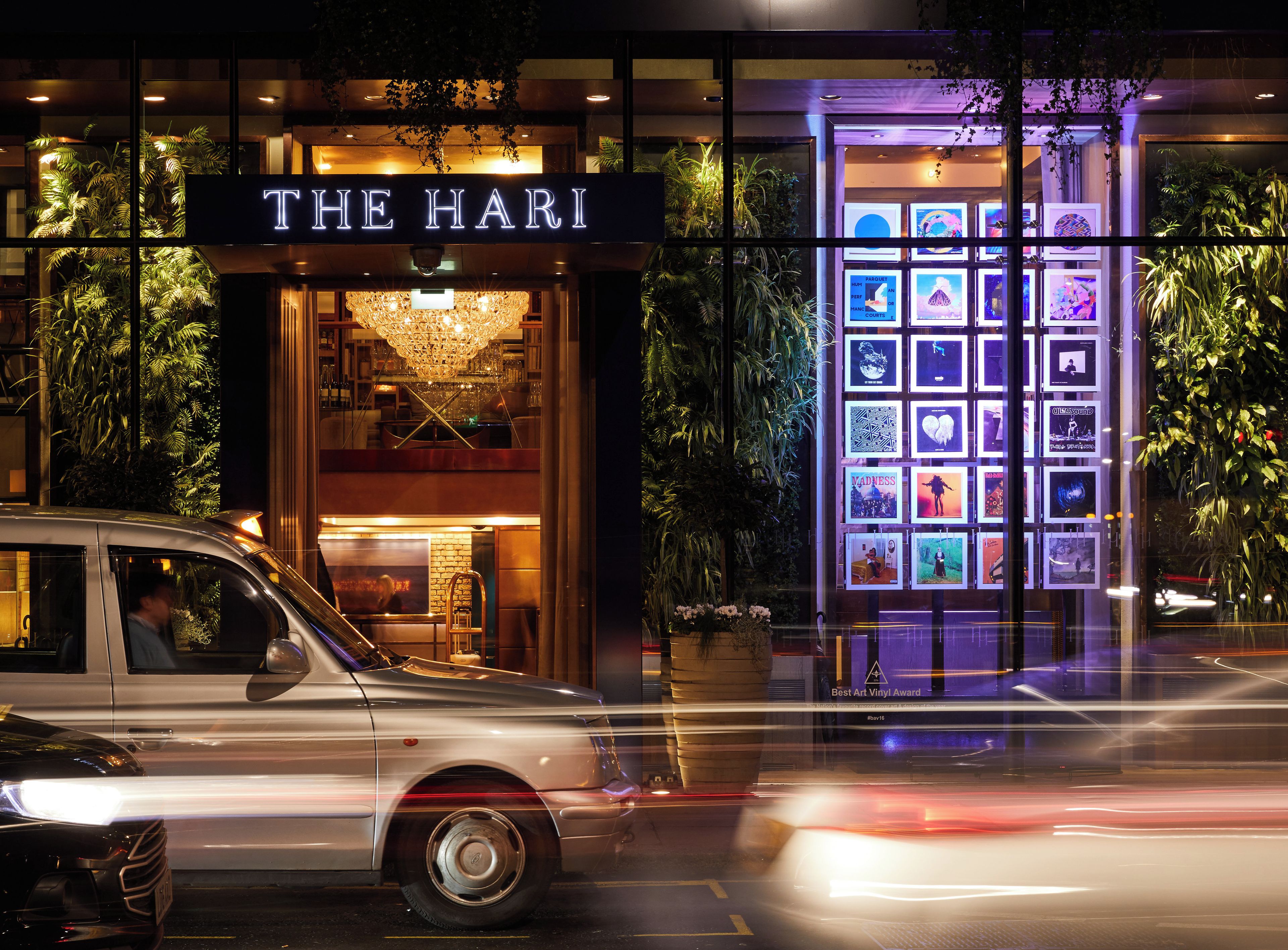 A building with a sign reading 'THE HARI' and a display of framed pictures.