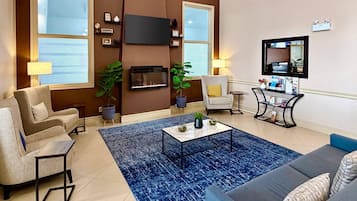 A living room with a fireplace, a sofa, a coffee table, and a TV.