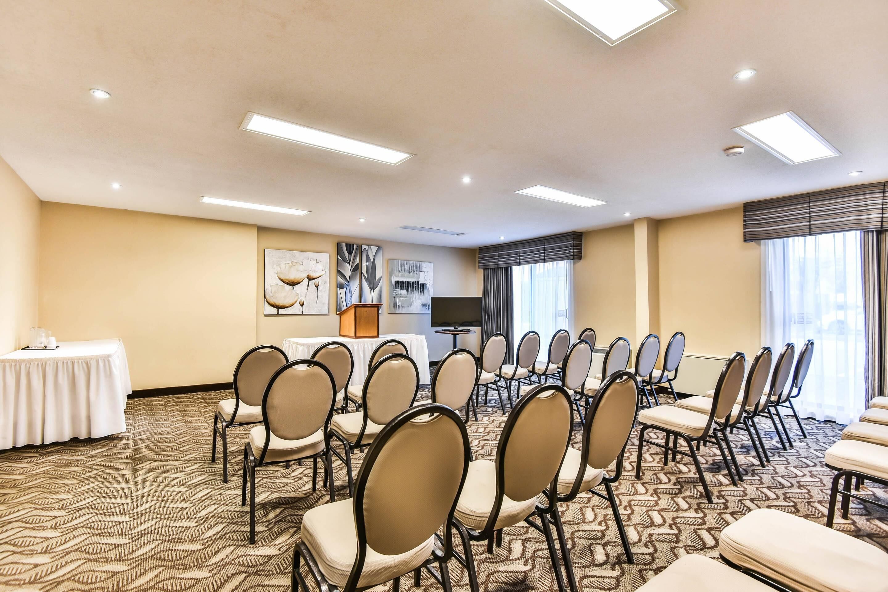 A conference room with rows of chairs, a table, and a television.