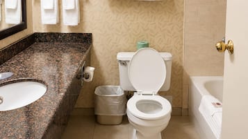 A bathroom with a marble sink, toilet, and bathtub.