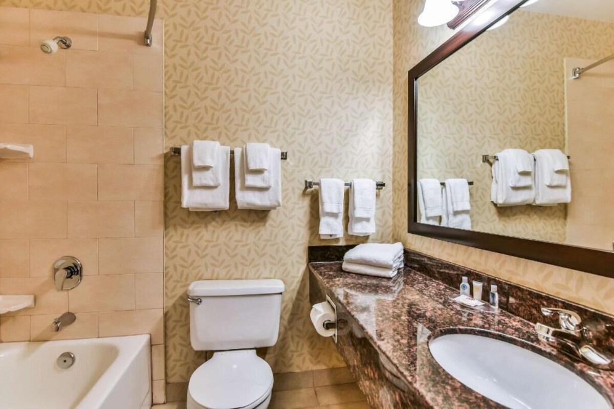 Un baño con inodoro, lavamanos y perchero para toallas.