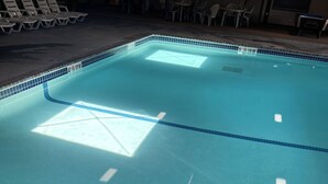 Une piscine aux eaux claires, dont les profondeurs sont clairement indiquées et dont le bord est revêtu de carreaux.