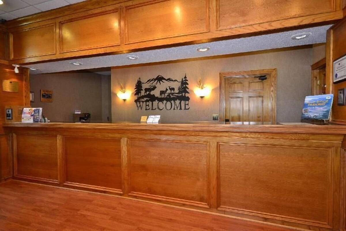 A reception desk with a 'WELCOME' sign, wooden paneling, and a door.