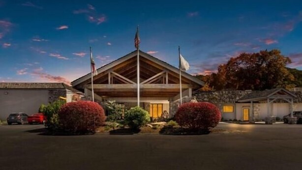 A building with a triangular roof, an American flag, and a flagpole.