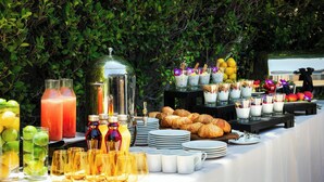 Una mesa de buffet con diferentes alimentos, bebidas y cristalería.