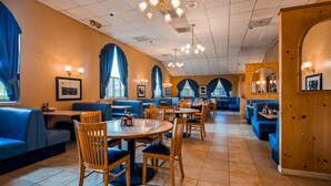 A restaurant with booths and tables, featuring blue seating and wooden decor. - Best Western El Grande Inn (Clearlake)