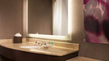 A modern bathroom with a double sink, a large mirror, and a towel rack.