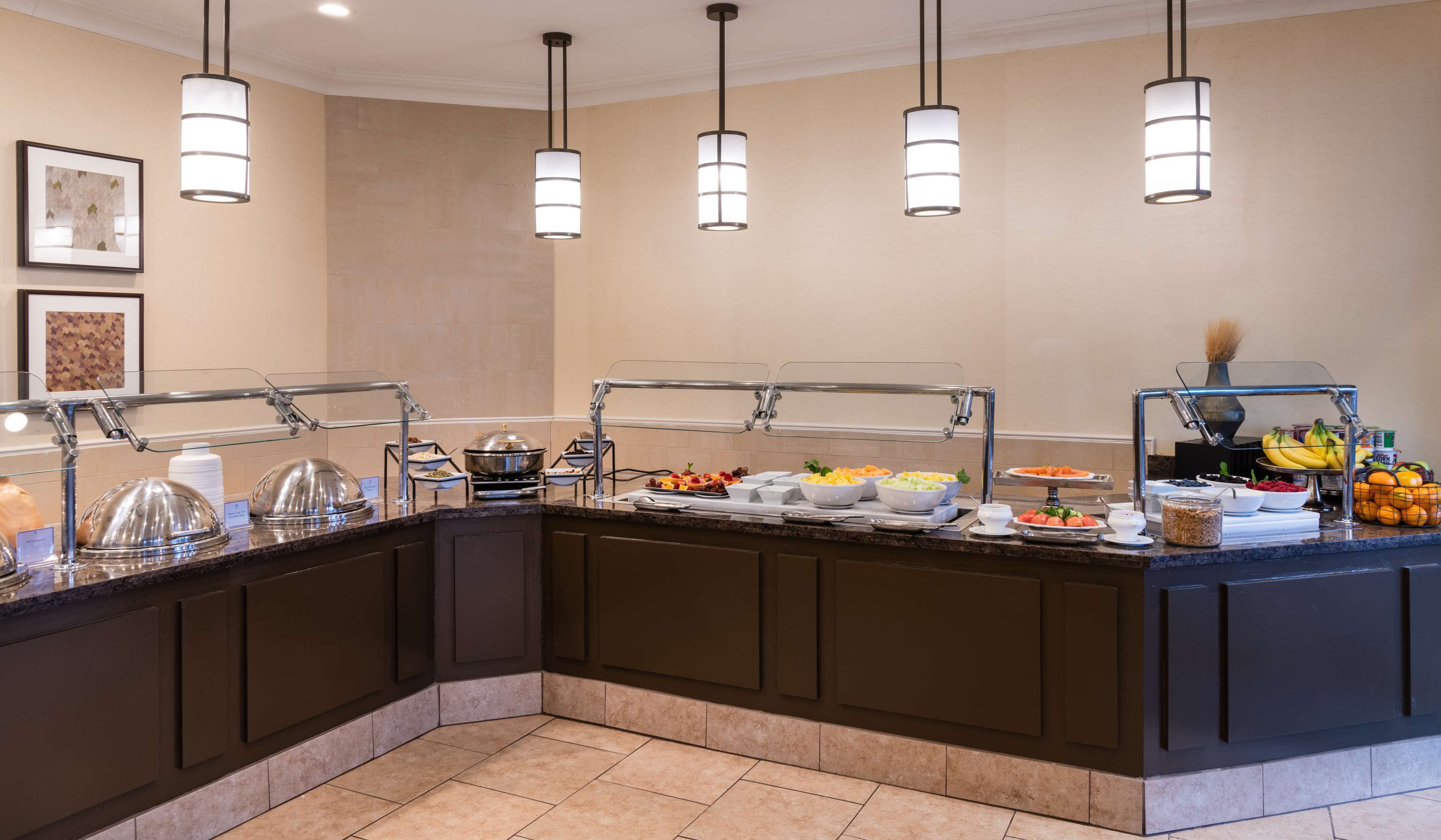 A buffet setup with various food items and a fruit display.