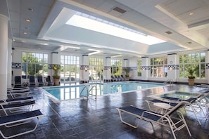 Una piscina techada, una piscina al aire libre de temporada, sombrillas