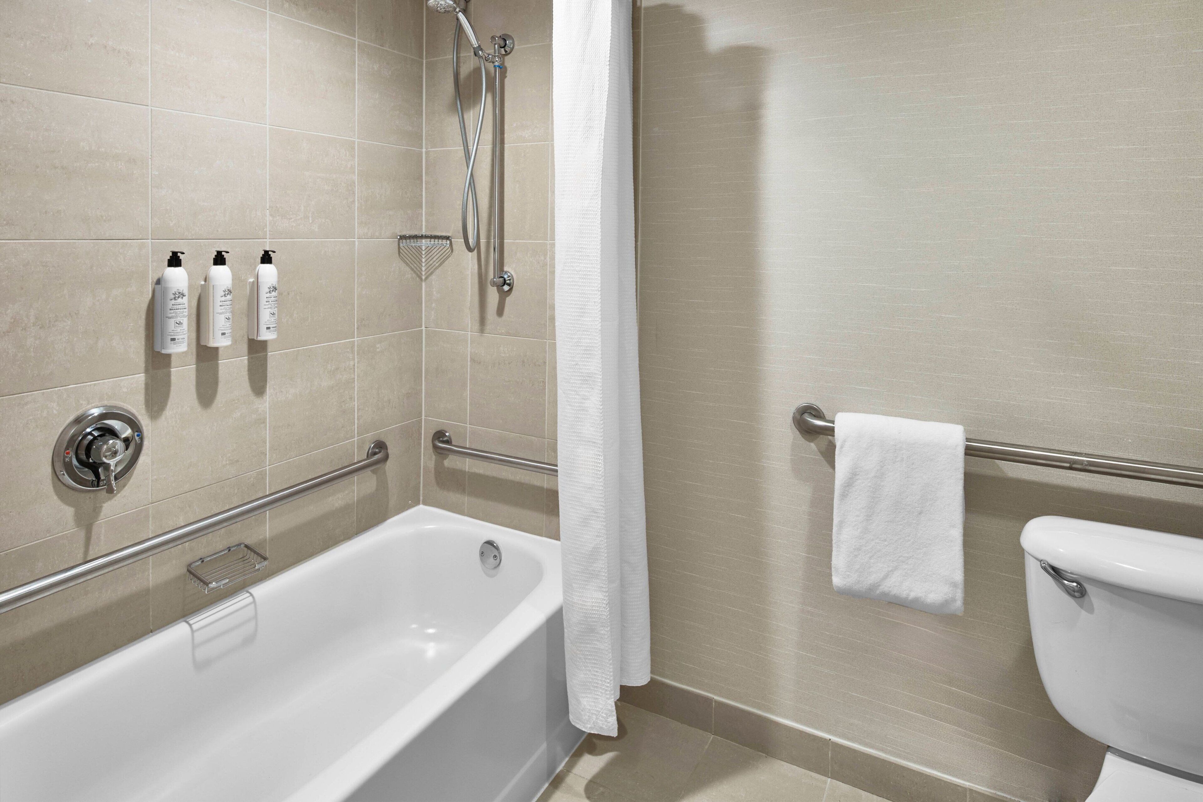 Un baño moderno con bañera, inodoro y zona de ducha.