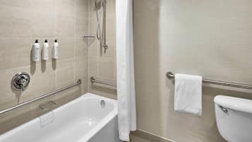 Un baño moderno con bañera, inodoro y zona de ducha.