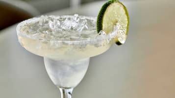 Un cóctel margarita con hielo y una rodaja de lima.