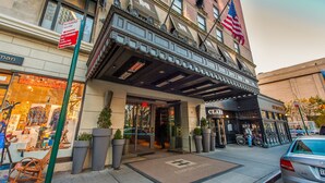 The Empire Hotel entrance with a no parking sign, a storefront with 'American Craft' signage, and an American flag. - Empire Hotel (New York)