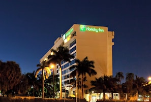Un hôtel Holiday Inn au design moderne, avec plusieurs étages et une enseigne bien visible.