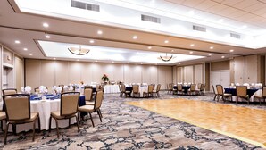 A conference room with multiple tables set for dining, equipped with chairs and table settings. - Holiday Inn Miami West - Airport Area by IHG (Hialeah)