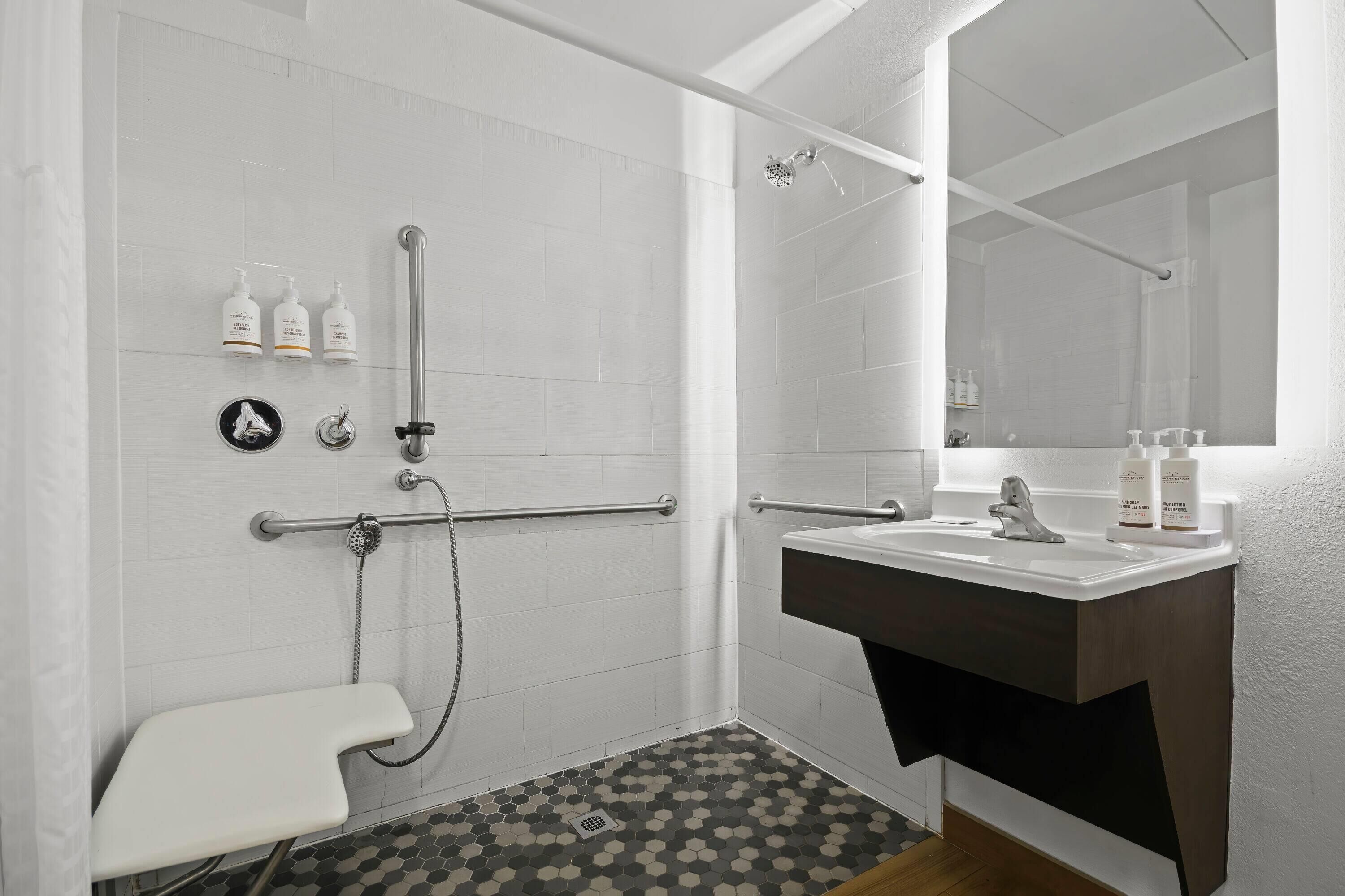 A modern bathroom with a shower, toilet, and sink.