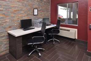 A workspace with two desks, computers, and chairs.