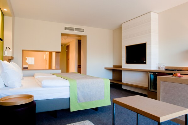 A hotel room with a bed, a desk, a television, and a bathroom. - Silva Hotel Spa - Balmoral (Spa)