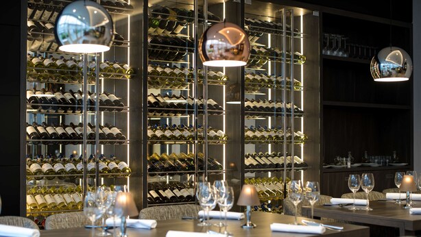 A restaurant with multiple tables set for dining, each with wine glasses and cutlery. - NH Bussum Jan Tabak (Bussum)