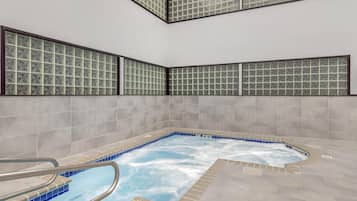 Un jacuzzi con suelo de baldosas y cerramiento de vidrio.