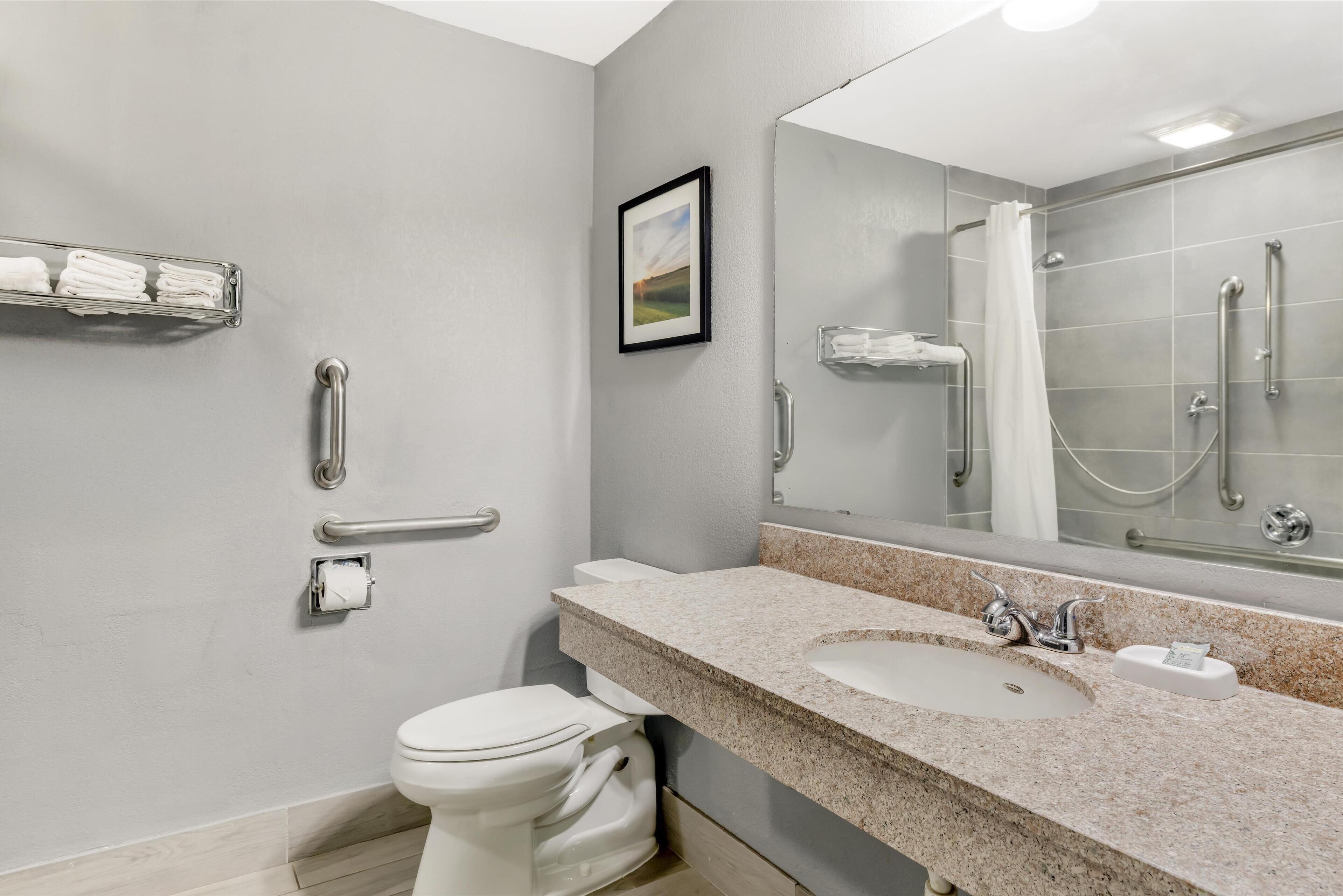 Un baño moderno con inodoro, lavamanos y ducha.