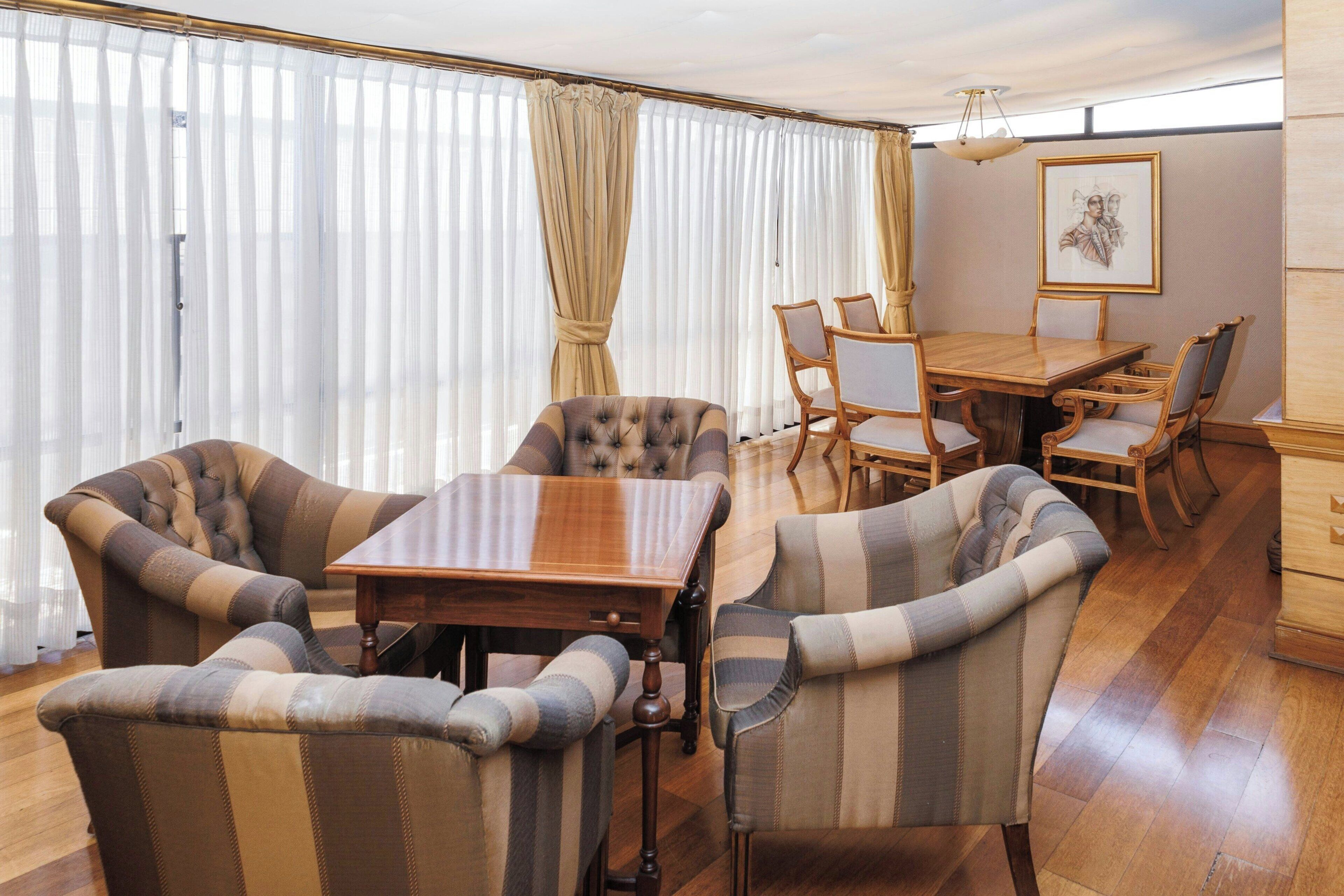 A dining area with a wooden table and striped upholstered chairs.
