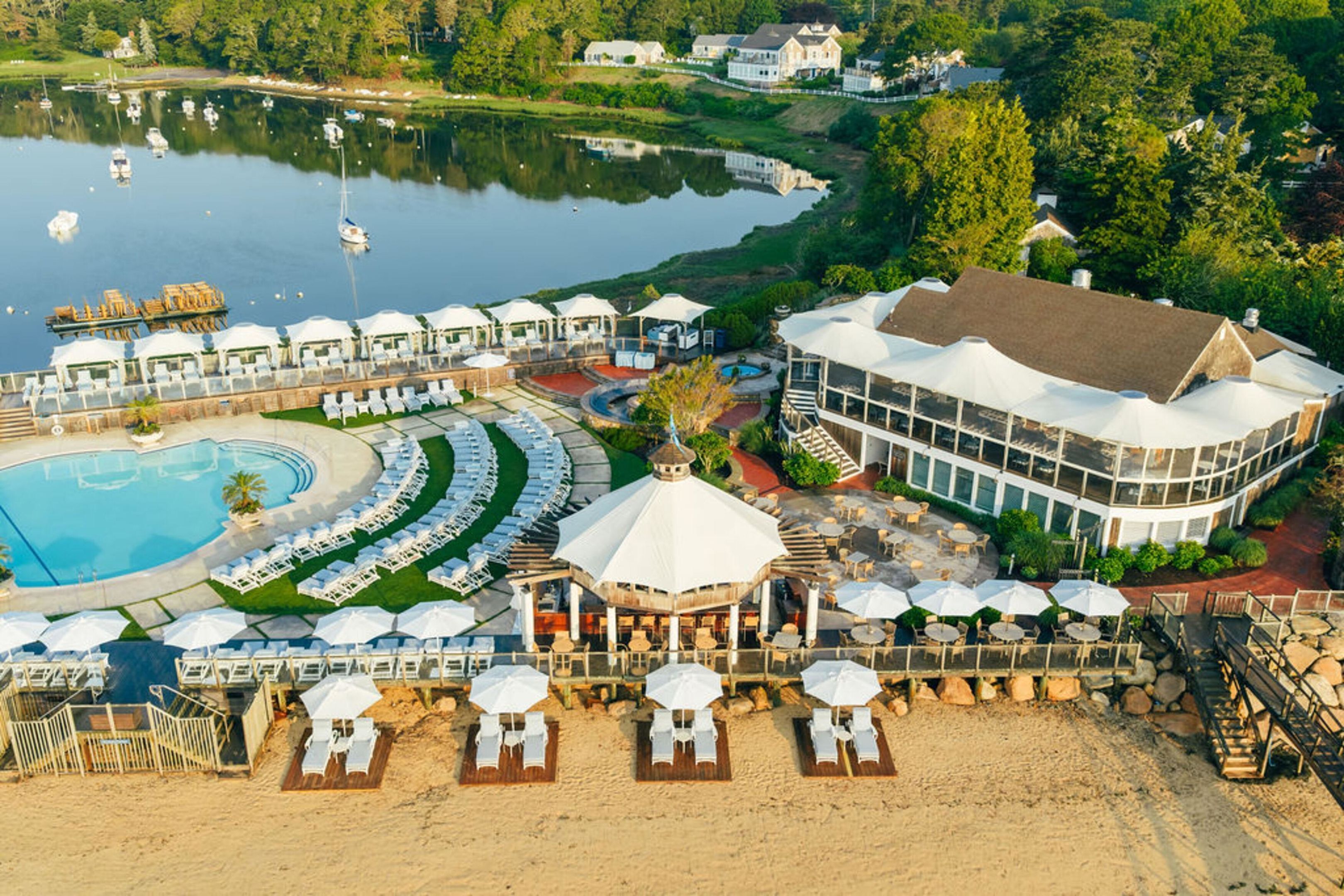A resort with a swimming pool, beach area, and a large building with a dome structure.