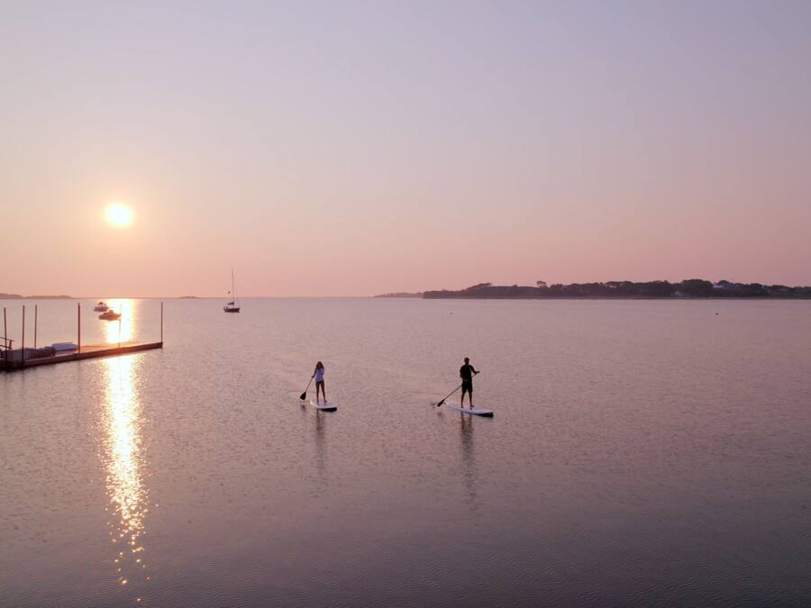 Unes aigües tranquil·les amb un moll i barques.
