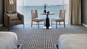 A room with a view of the sea, featuring a sofa, two chairs, a small table with a vase and a bottle, and a patterned carpet. - Wequassett Resort and Golf Club (Harwich)