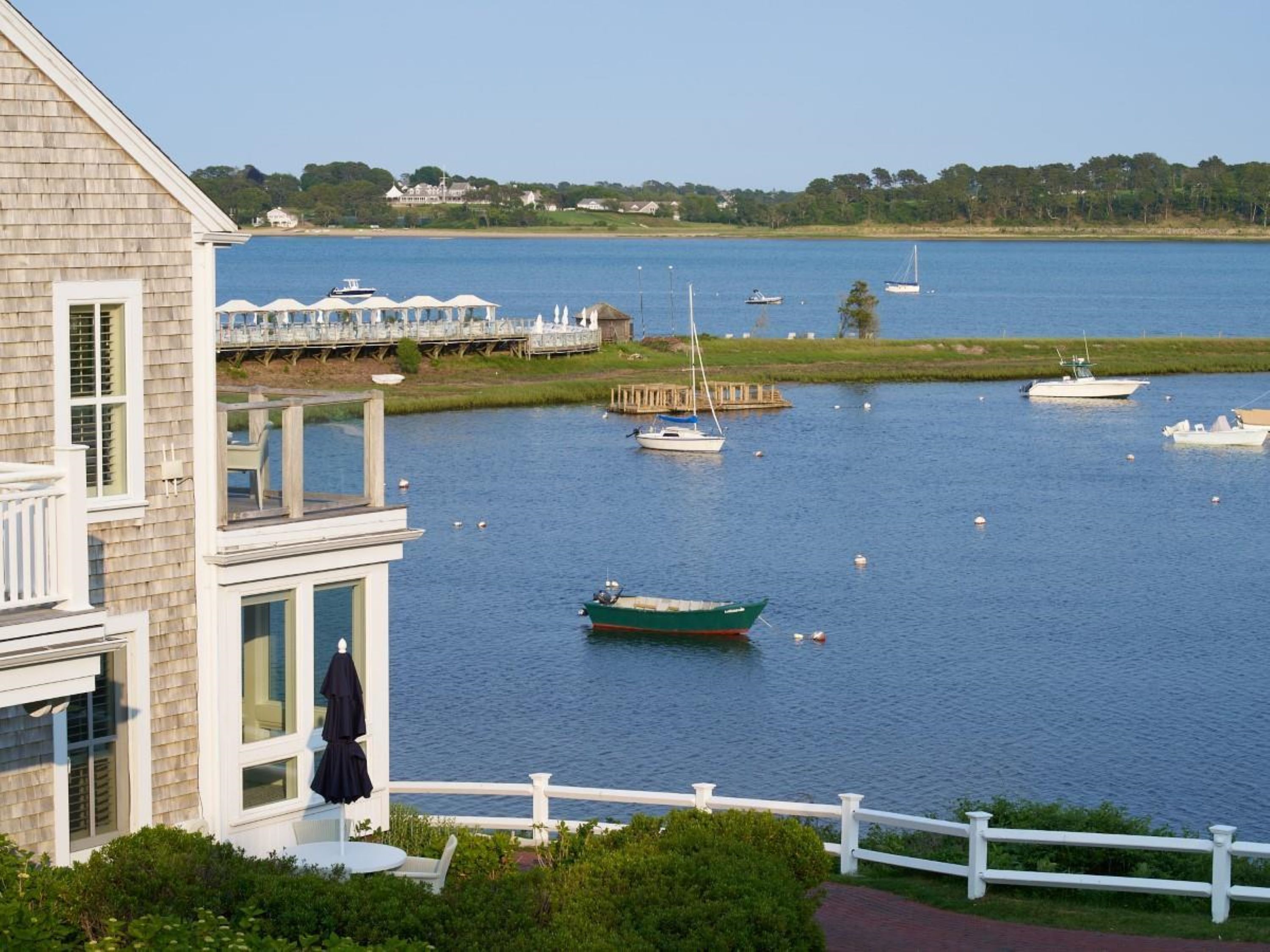 A waterfront property with a view of the water, a dock, and a building with a balcony.