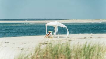 En privat strand, parasoller, badehåndklæder, strandbarer